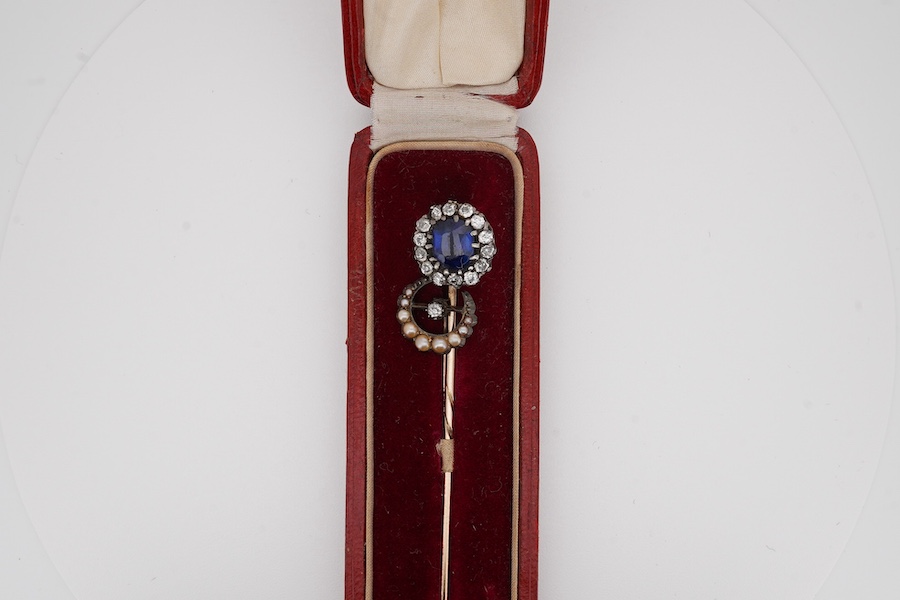 A late Victorian yellow metal, blue paste and diamond cluster set stick pin, 68mm, together with a 15ct, diamond and seed pearl set crescent stick pin. Condition - poor to fair